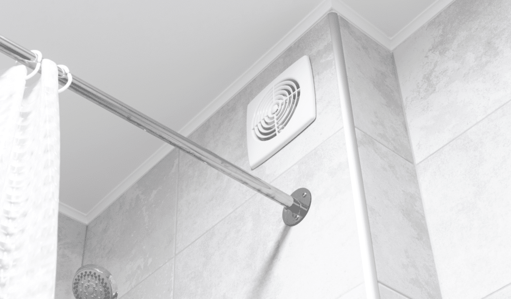 Extractor fan on bathroom wall above shower
